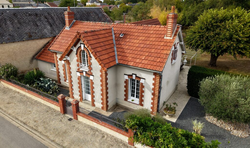 Vue aérienne d’une maison individuelle avec jardin, mettant en valeur le bien immobilier et son environnement.